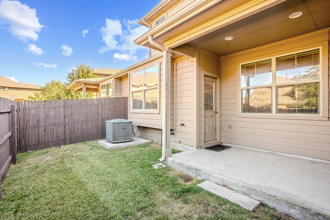 2880 Donnell Drive, Unit 2003 Round Rock, TX 78664 - Photo 26 of 27 a view of a backyard with table and chairs and wooden fence