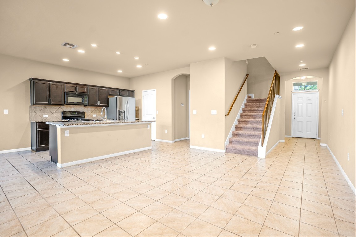 2880 Donnell Drive, Unit 2003 Round Rock, TX 78664 - Photo 6 of 27 a view of kitchen with stainless steel appliances cabinets and lounge chair