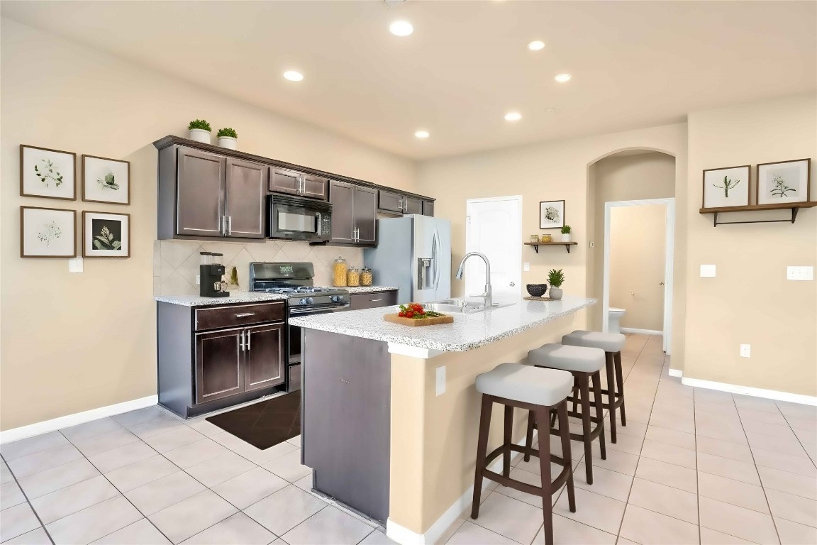 2880 Donnell Drive, Unit 2003 Round Rock, TX 78664 - Photo 7 of 27 a kitchen with stainless steel appliances kitchen island granite countertop a sink and cabinets