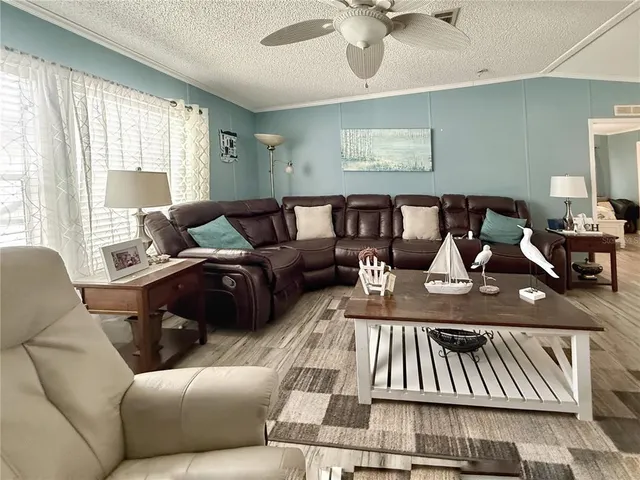 a living room with furniture ceiling fan and a window