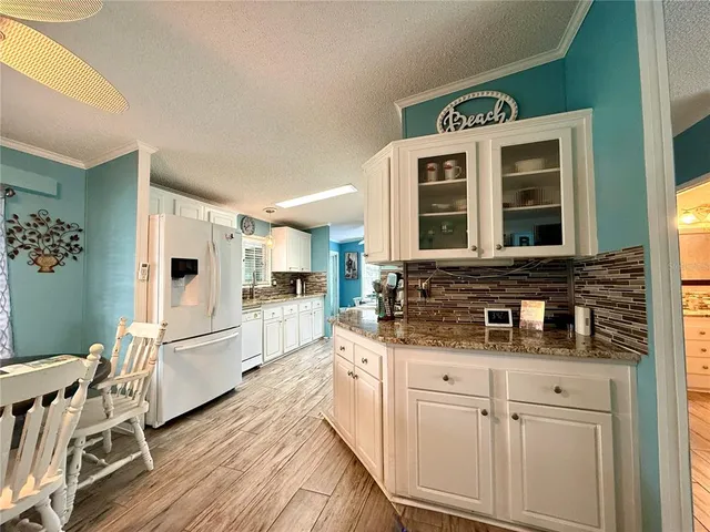 a kitchen with stainless steel appliances granite countertop a stove and white cabinets