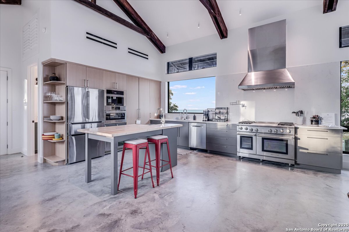 6031 Loop 1781 Rockport, TX 78382 - Photo 12 of 42 a kitchen with stainless steel appliances kitchen island granite countertop a table chairs sink and cabinets