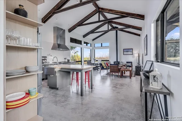 a kitchen with stainless steel appliances granite countertop a table chairs and a wooden floors