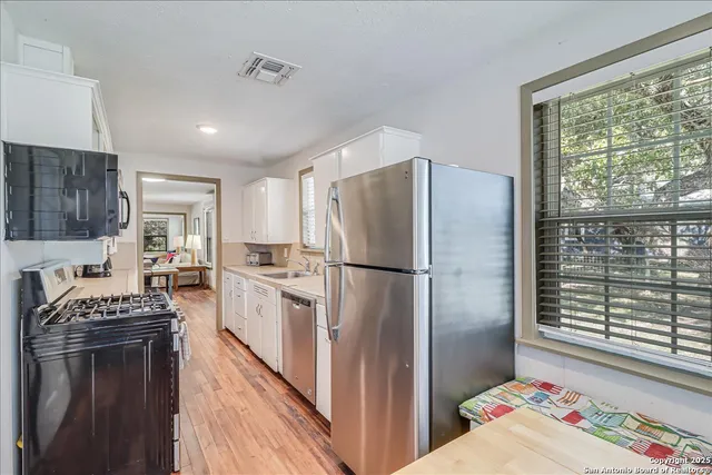 a kitchen with a sink a stove and cabinets