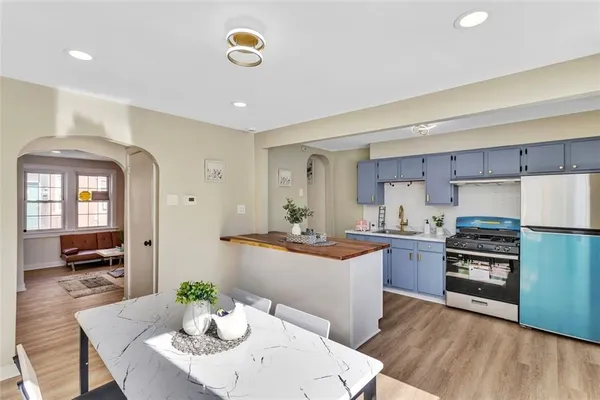a kitchen with stainless steel appliances granite countertop a kitchen island hardwood floor sink stove dining table and chairs