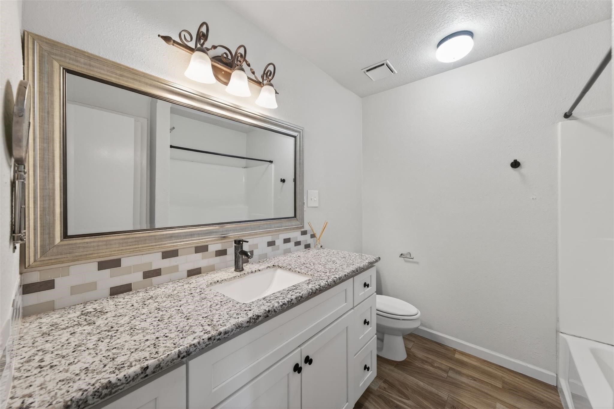 17002 Dew Drop Lane Houston, TX 77095 - Photo 19 of 24 a bathroom with a granite countertop sink a toilet and a mirror