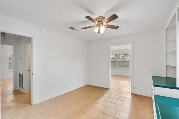a view of a room with cabinet cabinet a chandelier fan and windows
