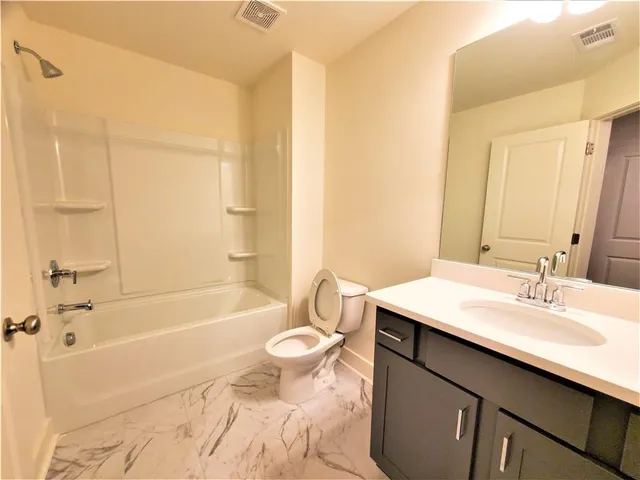 a bathroom with a sink a toilet a mirror and bathtub
