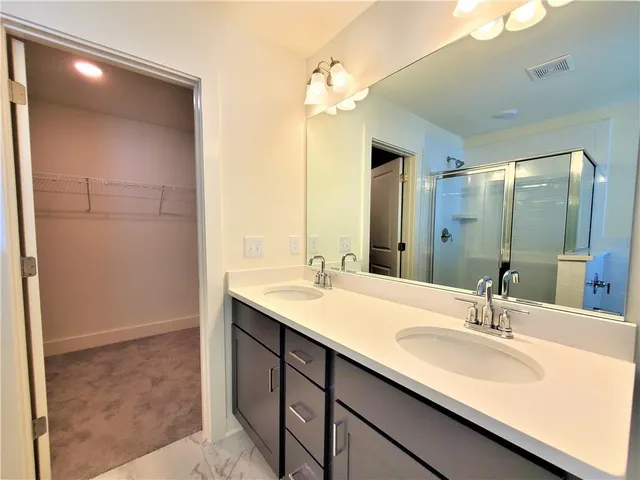 a bathroom with a sink double vanity and a mirror