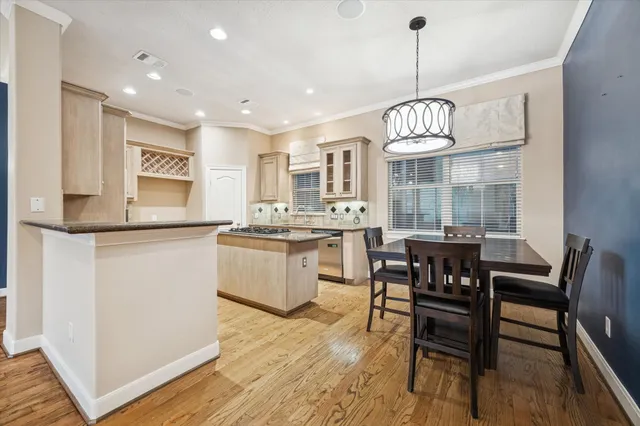 a kitchen with a dining table chairs sink and cabinets