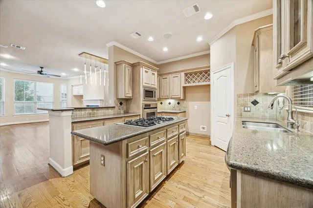 a kitchen with stainless steel appliances granite countertop a sink stove and cabinets