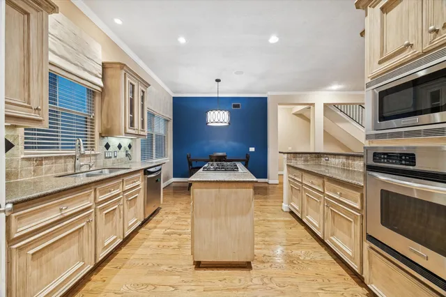 a kitchen with stainless steel appliances granite countertop a stove a sink and a microwave