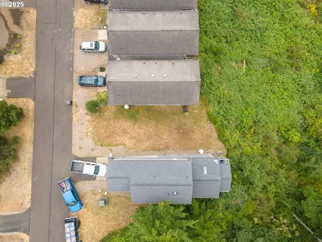 an aerial view of a house with a yard and lake view
