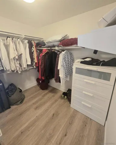a view of walk in closet with clothes and shoes