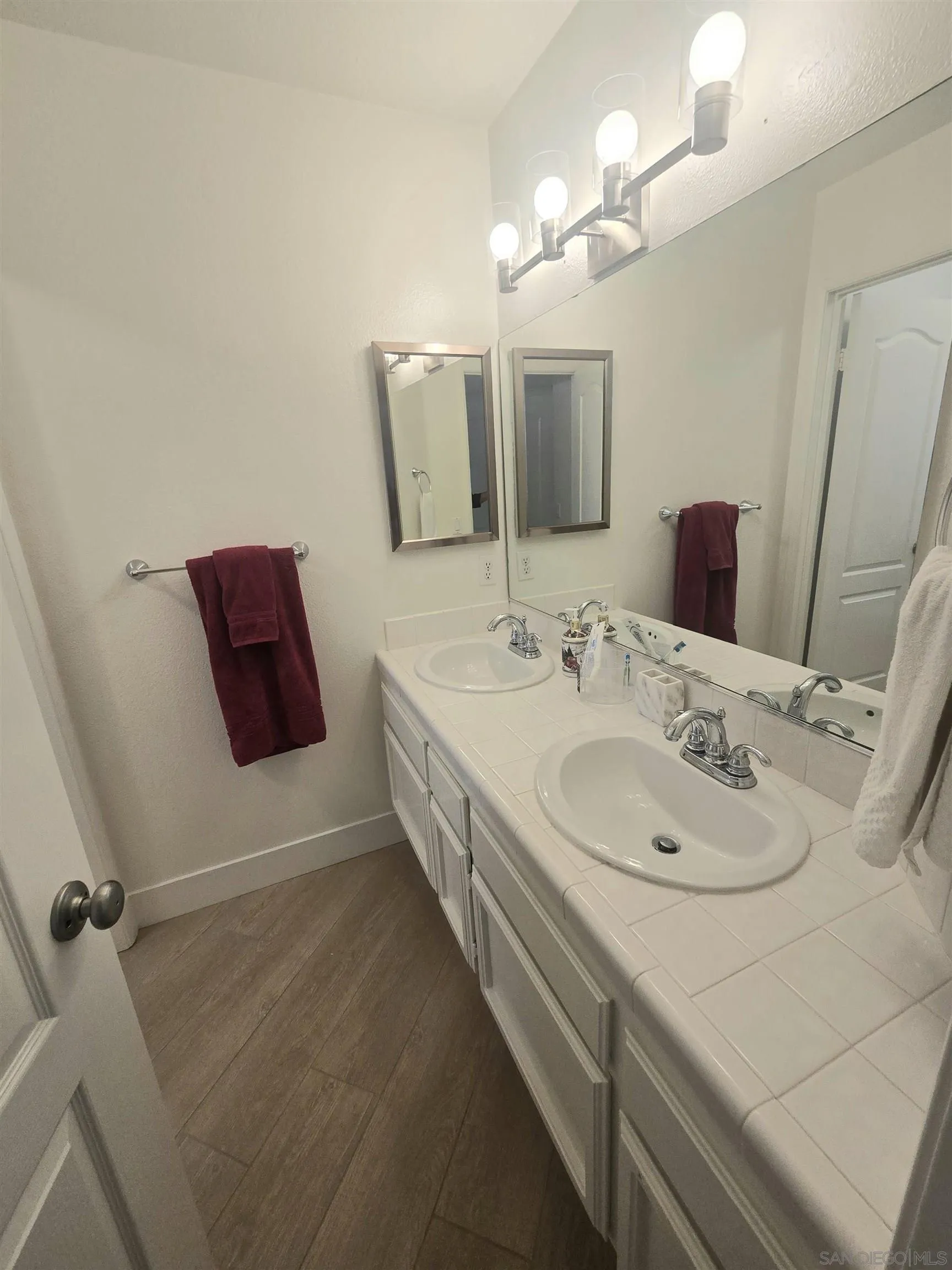 4802 Baroque Terrace Oceanside, CA 92057 - Photo 16 of 26 a bathroom with a double vanity sink and a mirror