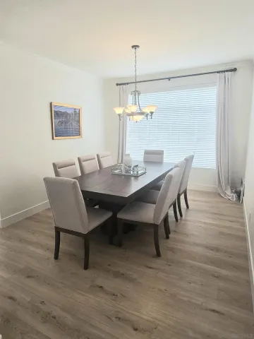 a dining room with furniture wooden floor a rug and a chandelier