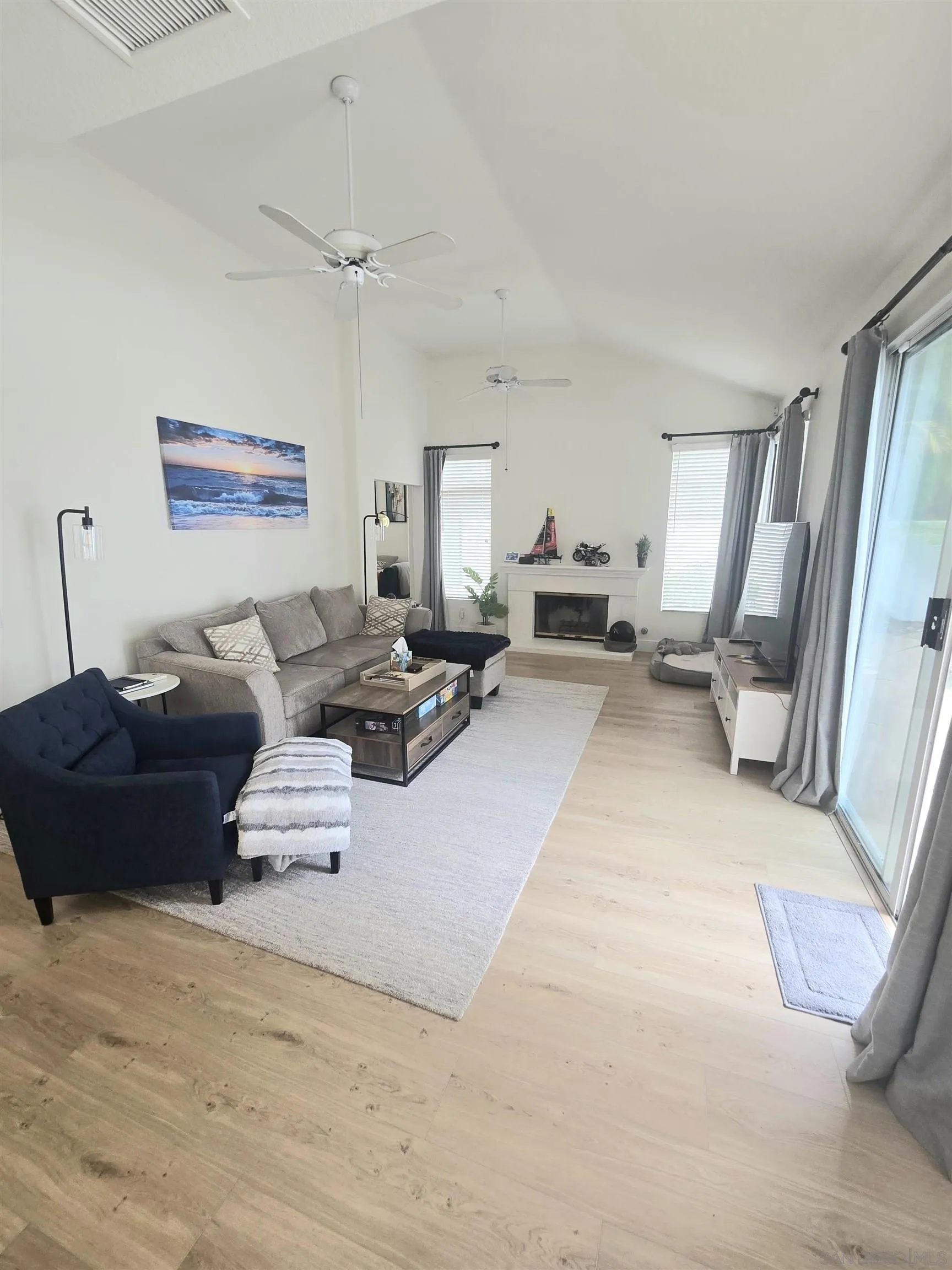 4802 Baroque Terrace Oceanside, CA 92057 - Photo 9 of 26 a living room with furniture large mirror and a ceiling fan