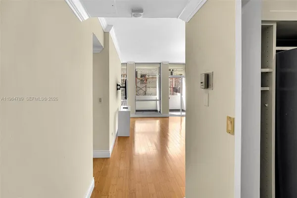 a view of a hallway with wooden floor and a living room