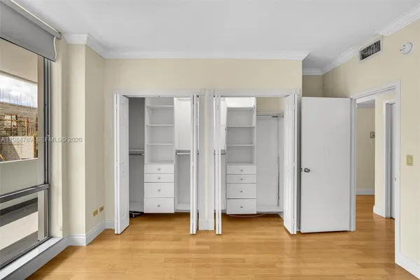 a view of an empty room with closet and a window