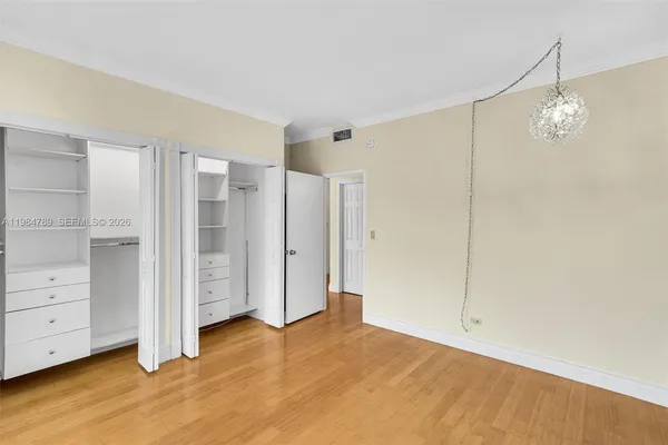 a view of empty room with wooden floor