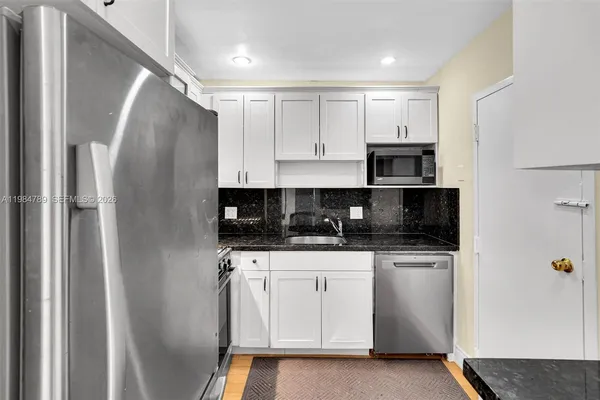 a kitchen with stainless steel appliances a refrigerator sink and cabinets