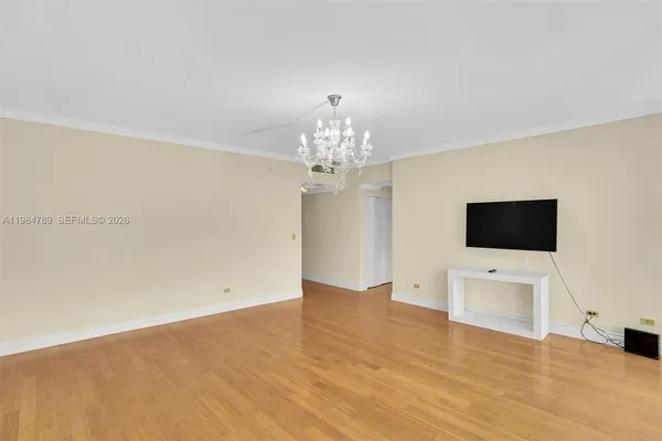 a living room with a flat screen tv a chandelier and a flat screen tv