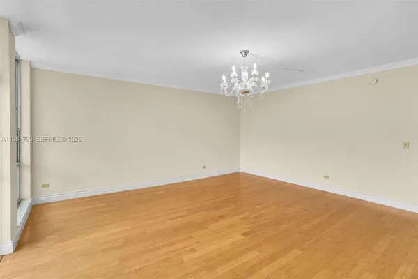 a view of a big room with wooden floor and chandelier