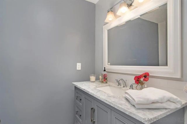 a bathroom with a granite countertop sink and a mirror