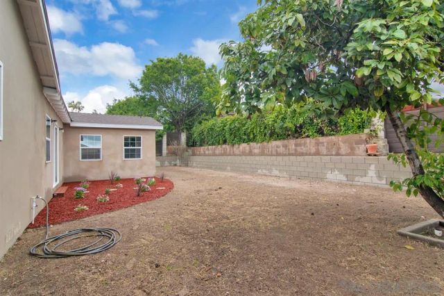 a backyard of a house with table and chairs