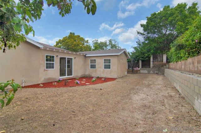 a view of a house with backyard and sitting area