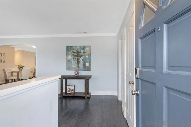a view of a hallway with wooden floor and a bathroom