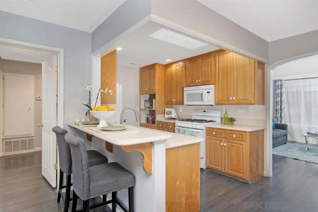 a kitchen with a stove a sink a dining table and chairs