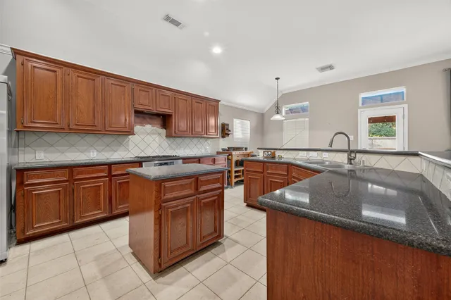 a kitchen with stainless steel appliances granite countertop a sink stove and cabinets