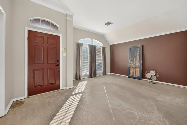 a view of an empty room with closet and entryway