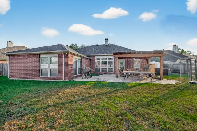 a backyard of a house with table and chairs