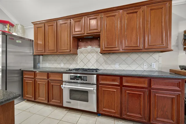 a kitchen with granite countertop wooden cabinets and a stove top oven