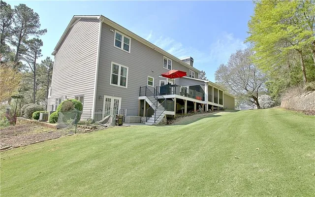 a view of a house with backyard and trees