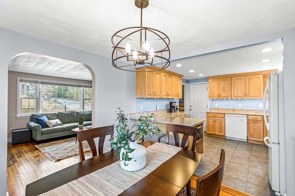 352 West Street Reading, MA 01867 - Photo 13 of 37 a dining room with wooden floor a chandelier a wooden table and chairs
