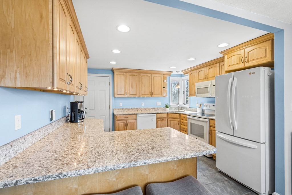 352 West Street Reading, MA 01867 - Photo 20 of 37 a kitchen with stainless steel appliances granite countertop a refrigerator sink and cabinets