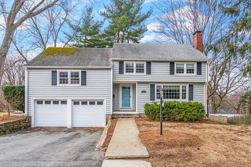 352 West Street Reading, MA 01867 - Photo 5 of 37 a view of a white house with large windows and a small yard