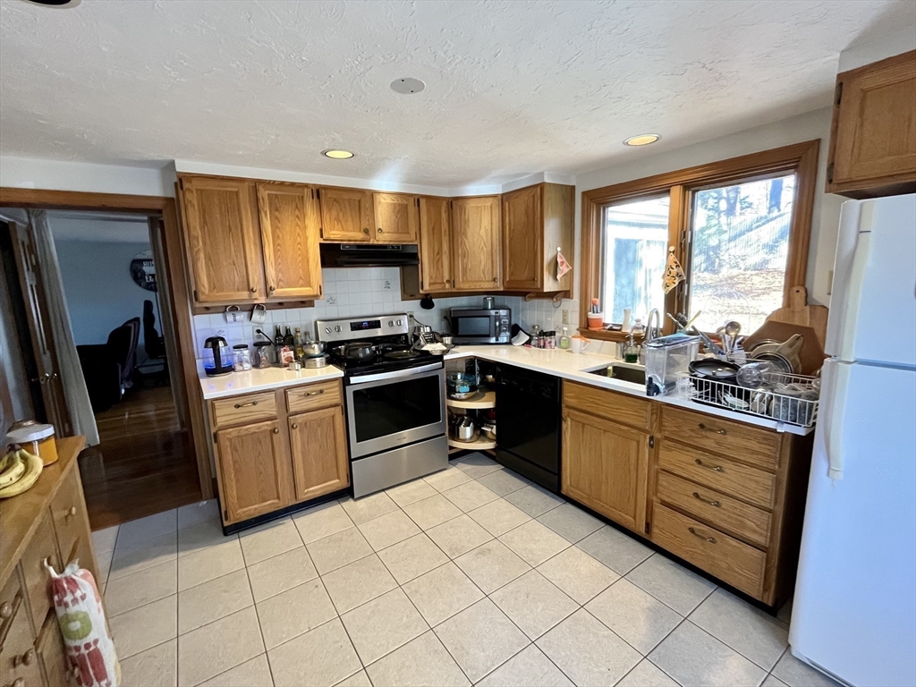 18 Lariviere Road Framingham, MA 01701 - Photo 4 of 8 a kitchen with stainless steel appliances granite countertop a stove sink and cabinets