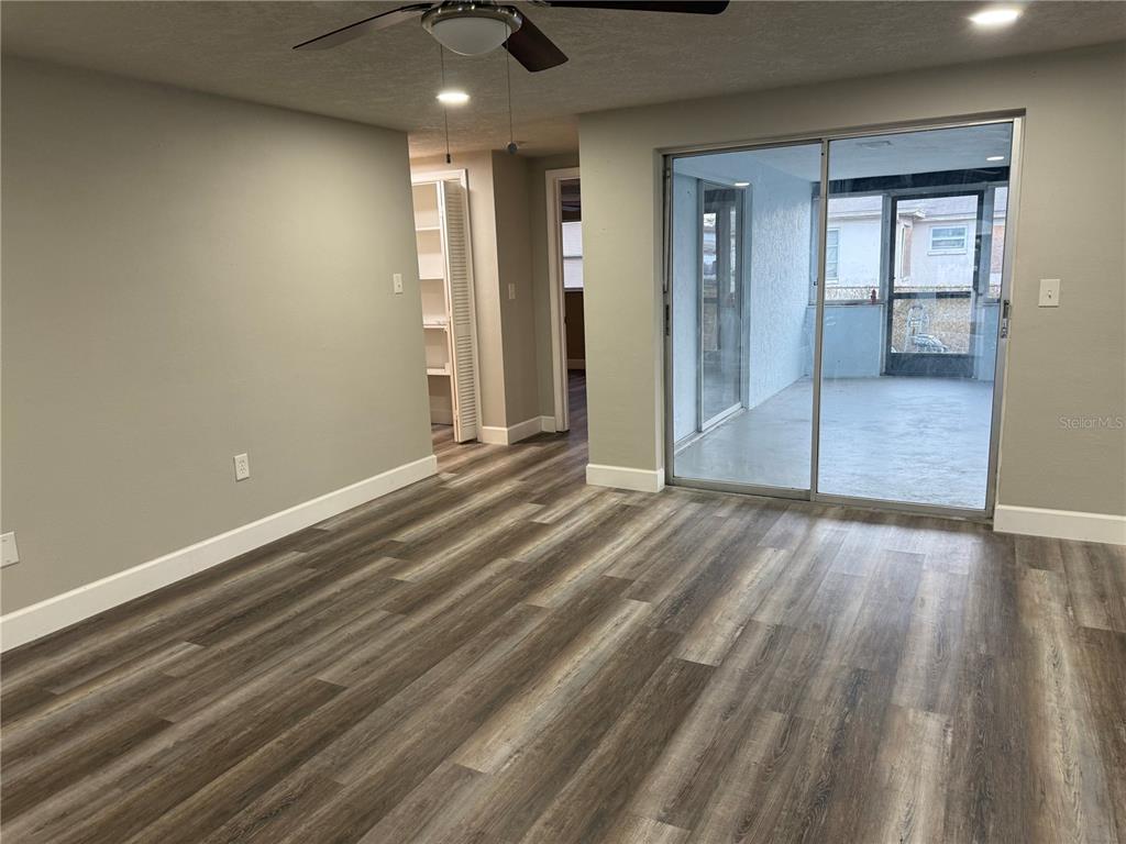 7104 Ingleside Drive Port Richey, FL 34668 - Photo 4 of 14 en empty room with wooden floor and windows