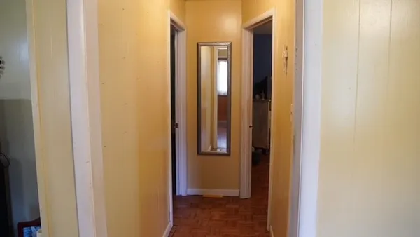 a view of a hallway with wooden floor