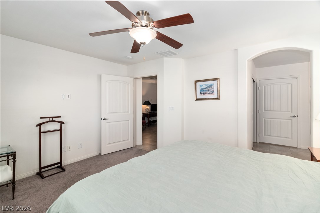 2269 Chandler Ranch Place Laughlin, NV 89029 - Photo 23 of 96 Carpeted Primary bedroom with ceiling fan and arched walkways