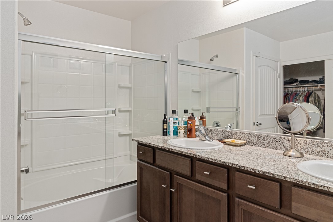 2269 Chandler Ranch Place Laughlin, NV 89029 - Photo 26 of 96 Full Primary bath featuring a walk in closet, combined bath / shower with glass door, and double vanity