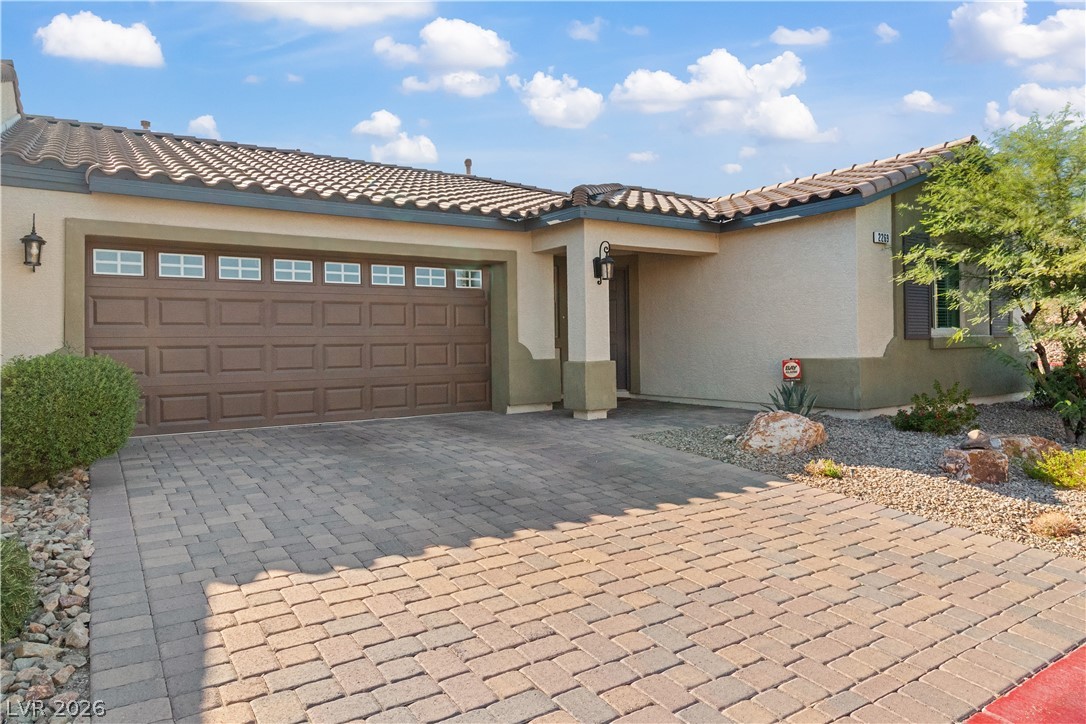 2269 Chandler Ranch Place Laughlin, NV 89029 - Photo 54 of 96 Mediterranean / spanish-style house with stucco siding, large decorative paver driveway, a garage, and a tiled roof