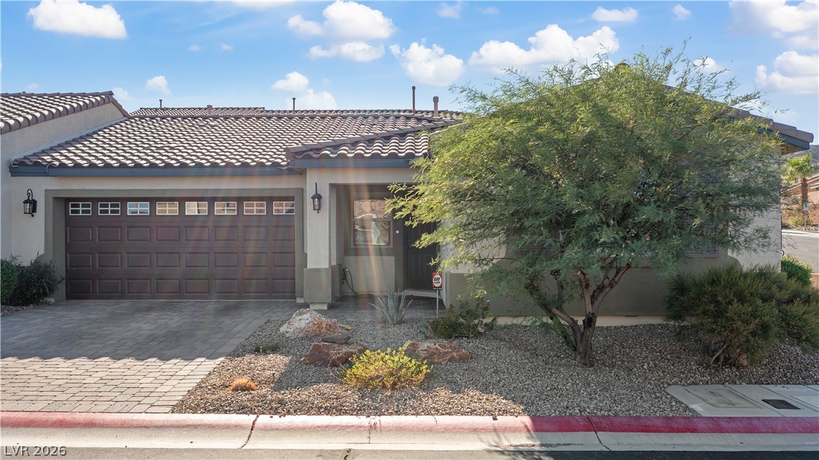 2269 Chandler Ranch Place Laughlin, NV 89029 - Photo 62 of 96 View of front of house featuring stucco siding, decorative driveway, an attached garage, and a tiled roof