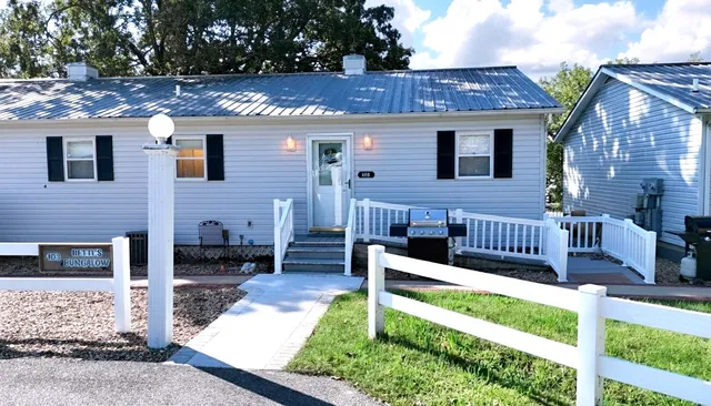 a view of a house with wooden deck and a yard