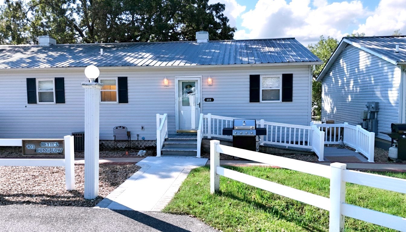 a view of a house with wooden deck and a yard