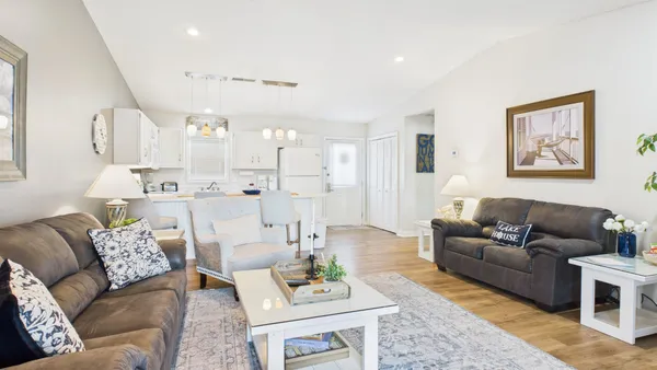 a living room with furniture kitchen view and a table